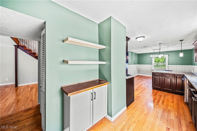 kitchen featuring hanging light fixtures, a textured ceiling, and light hardwood / wood-style floors