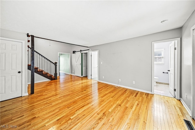 interior space featuring light hardwood / wood-style floors and a barn door