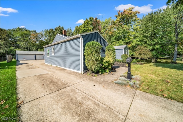 view of side of home featuring an outdoor structure, a yard, and a garage