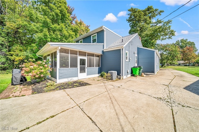 rear view of house featuring a patio, central AC, and a sunroom