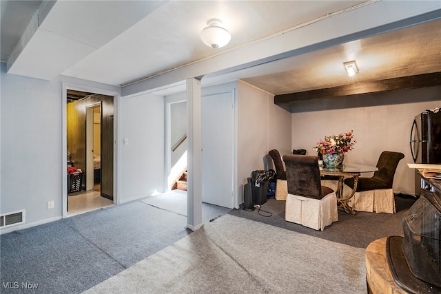 basement with light colored carpet and black refrigerator