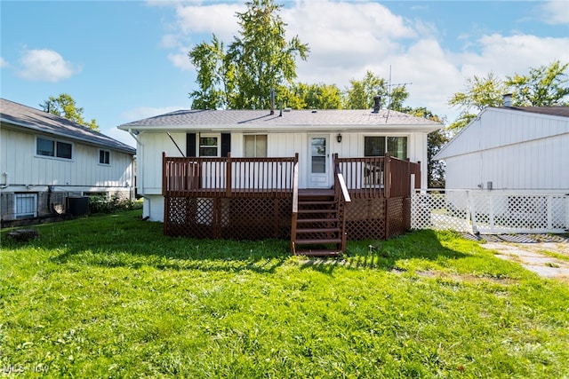 back of property featuring a lawn and a deck