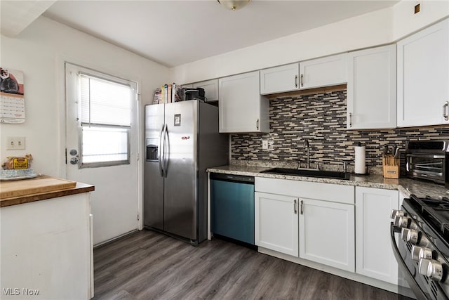 kitchen with white cabinets, appliances with stainless steel finishes, dark hardwood / wood-style flooring, and sink