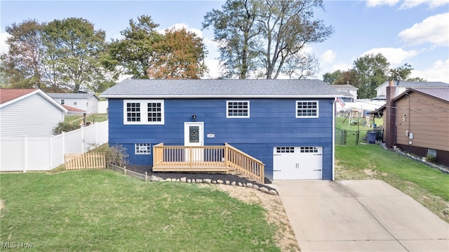 split foyer home featuring a front yard, a garage, and a wooden deck