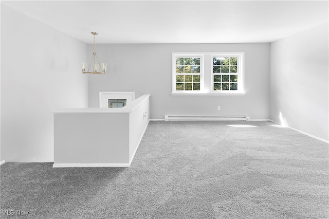 carpeted spare room featuring an inviting chandelier and baseboard heating