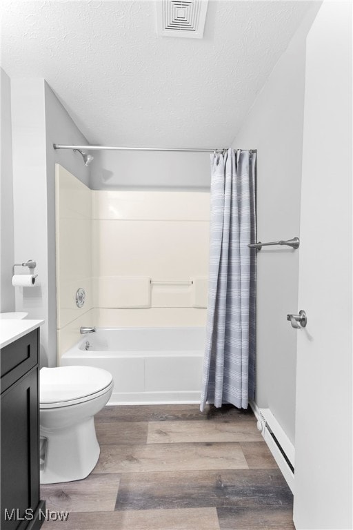 full bathroom with toilet, shower / bath combo with shower curtain, hardwood / wood-style floors, vanity, and a textured ceiling