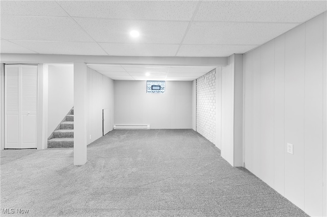 basement featuring a baseboard radiator, carpet floors, and a drop ceiling