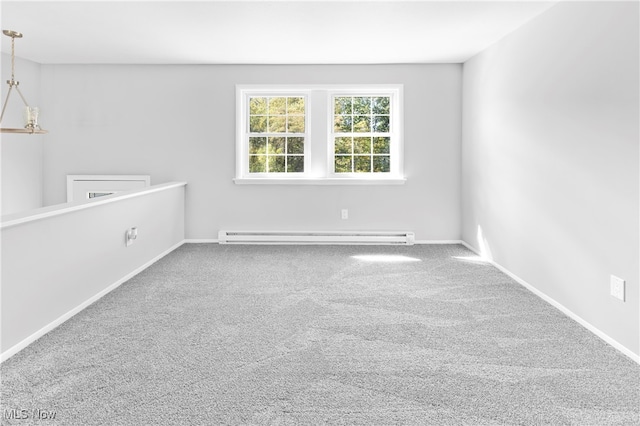 unfurnished room with a baseboard radiator, carpet flooring, and an inviting chandelier