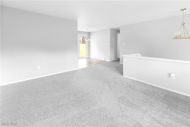 carpeted spare room with a chandelier