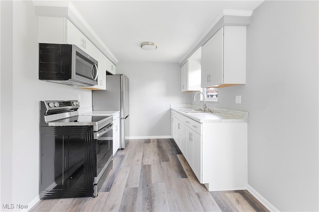 kitchen featuring light hardwood / wood-style floors, white cabinetry, stainless steel appliances, and sink