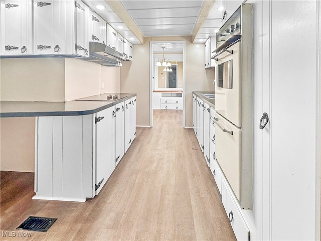 kitchen with pendant lighting, beamed ceiling, light hardwood / wood-style floors, and white cabinets