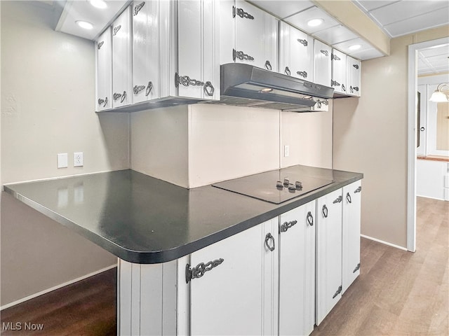 kitchen with light hardwood / wood-style floors, black electric stovetop, and white cabinets