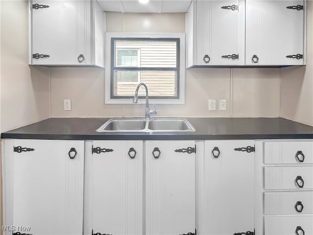 kitchen featuring white cabinets and sink