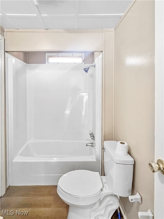 bathroom with hardwood / wood-style floors, toilet, and shower / washtub combination