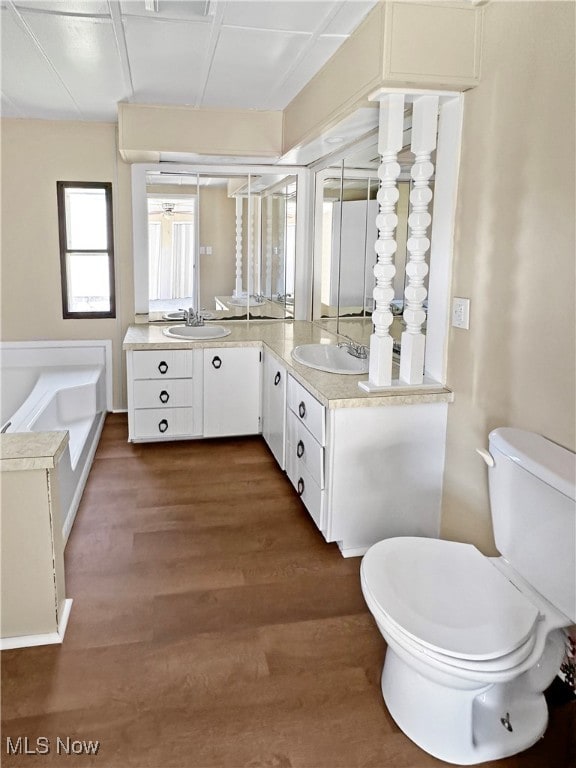 bathroom featuring a bathtub, hardwood / wood-style floors, vanity, and toilet