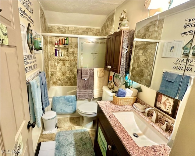 full bathroom featuring vanity, toilet, a textured ceiling, combined bath / shower with glass door, and tile patterned flooring