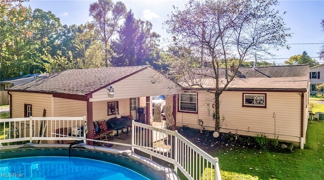 rear view of property featuring a yard and central air condition unit