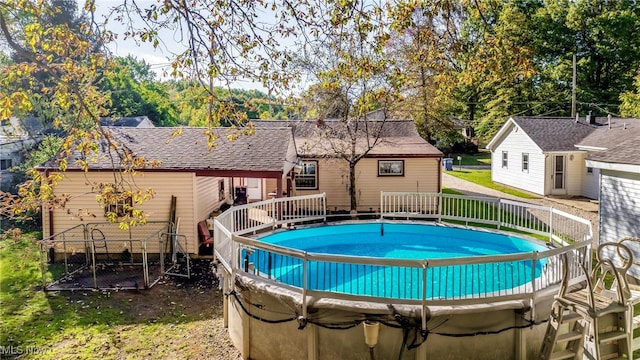 view of pool featuring a wooden deck and a lawn