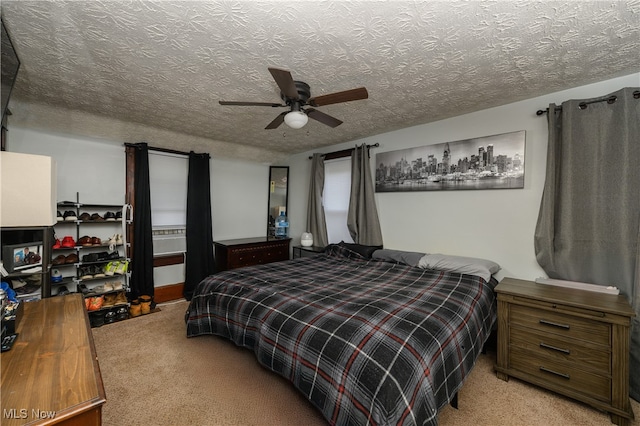 carpeted bedroom with ceiling fan and a textured ceiling