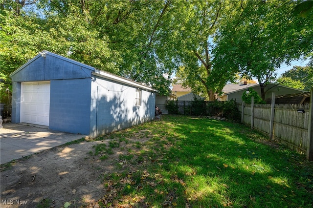 view of yard with a garage and an outbuilding