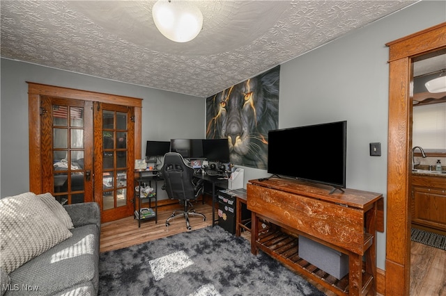 home office with hardwood / wood-style flooring, sink, and a textured ceiling