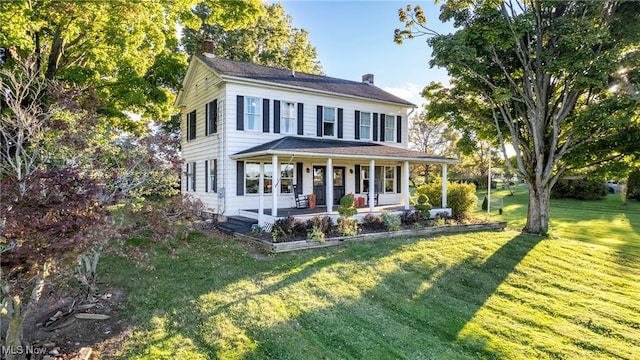 colonial home featuring a porch and a front yard