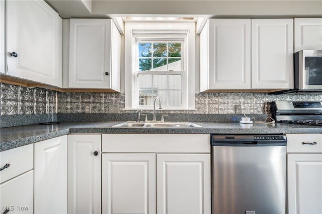 kitchen featuring appliances with stainless steel finishes, decorative backsplash, sink, and white cabinets