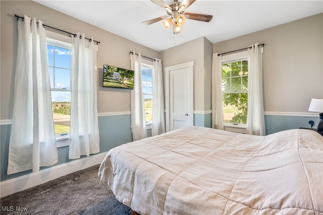 bedroom with carpet flooring, multiple windows, and ceiling fan