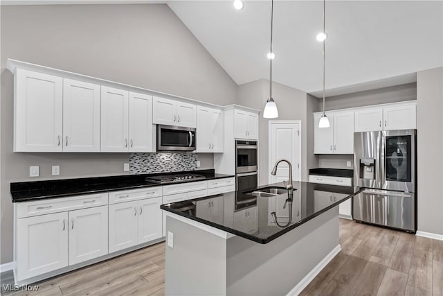 kitchen with white cabinets, sink, a kitchen island with sink, stainless steel appliances, and light hardwood / wood-style floors