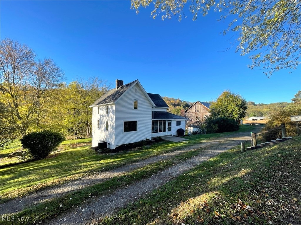 view of home's exterior with a yard and an outbuilding