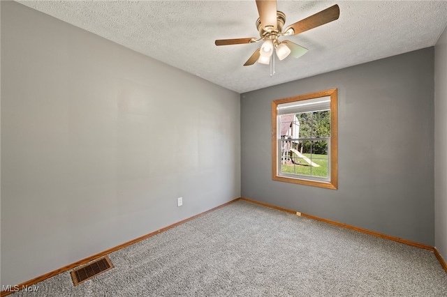 carpeted spare room with ceiling fan and a textured ceiling