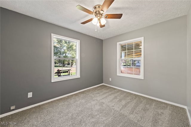 empty room featuring ceiling fan, a textured ceiling, and carpet flooring