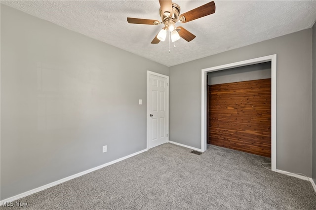 unfurnished bedroom with a closet, carpet, a textured ceiling, and ceiling fan