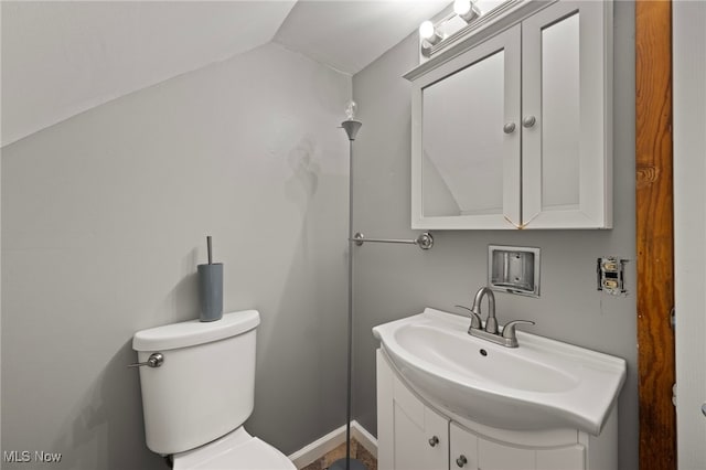 bathroom featuring vanity, lofted ceiling, and toilet