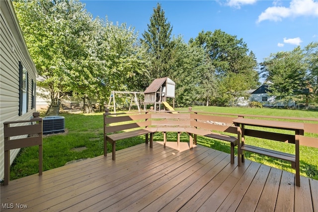 wooden terrace with a playground, cooling unit, and a yard