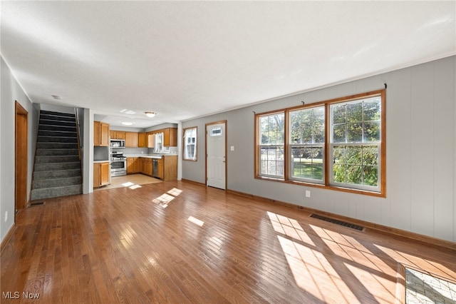 unfurnished living room with light hardwood / wood-style flooring and a wealth of natural light