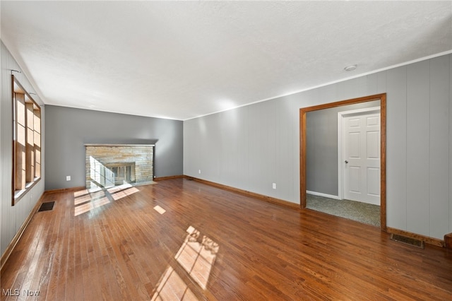 unfurnished living room featuring hardwood / wood-style flooring and a textured ceiling