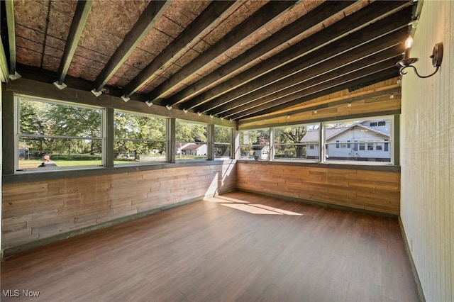 unfurnished sunroom with vaulted ceiling with beams