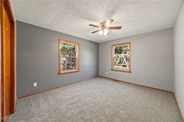 spare room featuring carpet flooring, ceiling fan, and a textured ceiling