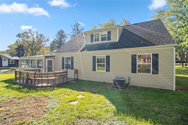 rear view of house featuring a lawn and central AC