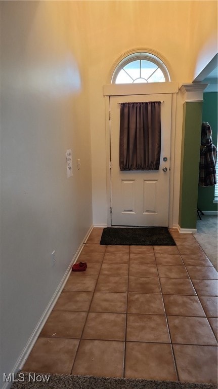 doorway with a high ceiling and tile patterned floors