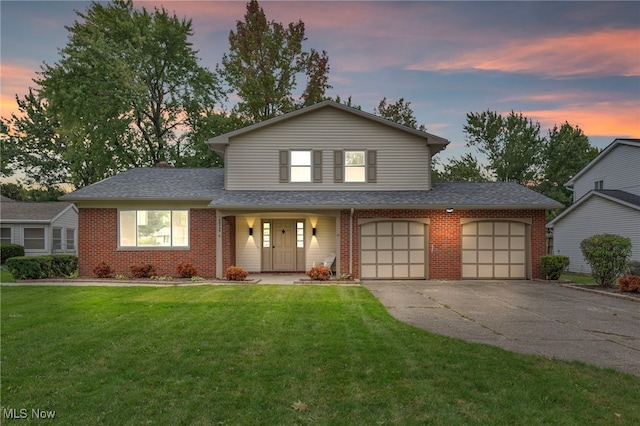 view of front of home with a garage, a lawn, and covered porch