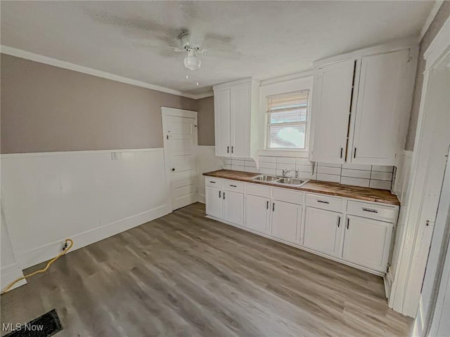 1504 W 19th St, Lorain, OH 44052 - kitchen featuring butcher block counters, light wood-style flooring, white cabinets, crown molding, and wainscoting