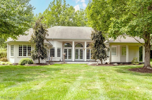 back of house featuring french doors and a lawn