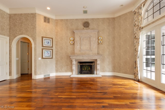 unfurnished living room with a high ceiling, crown molding, and wood-type flooring