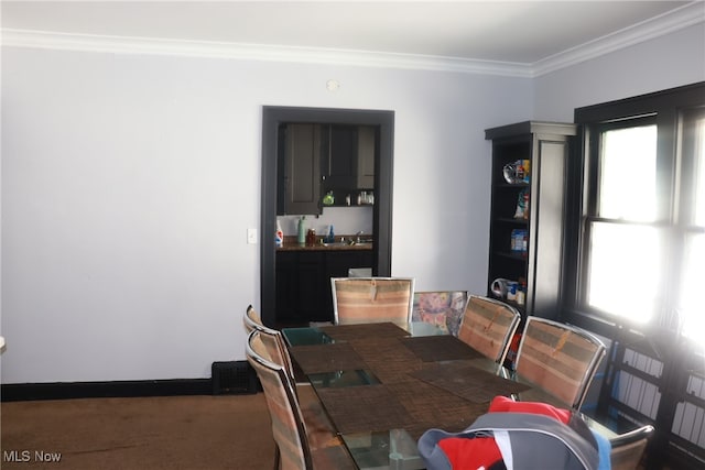 carpeted dining space with a wealth of natural light and crown molding