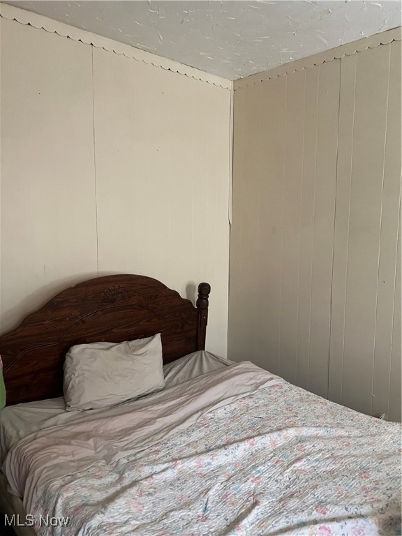 bedroom featuring wooden walls