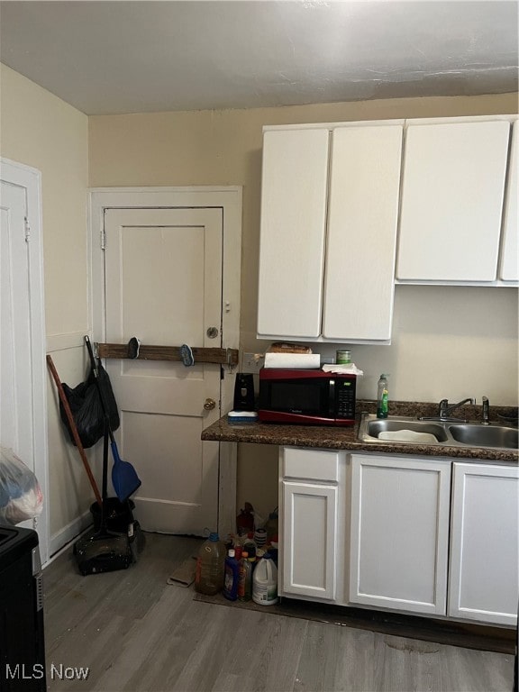 kitchen featuring white cabinets, dark hardwood / wood-style flooring, and sink