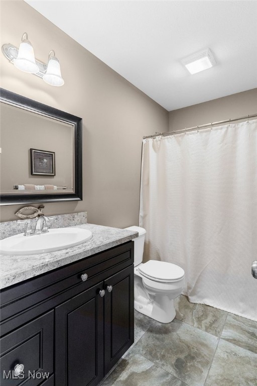 bathroom featuring vanity, toilet, and a shower with shower curtain