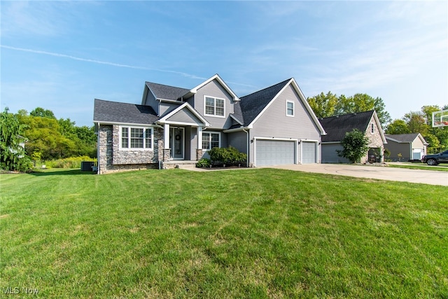 view of front of property with a garage, a front lawn, and central AC